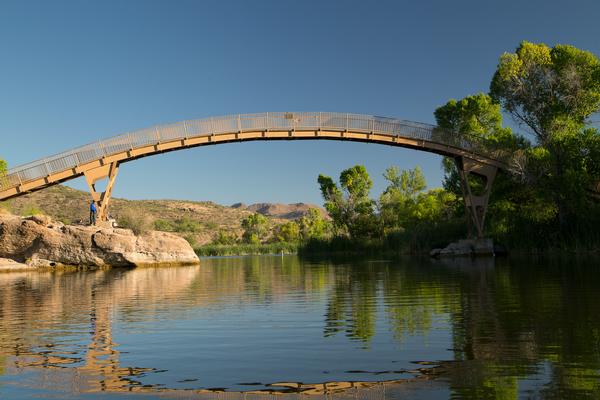 A man stands fishing near the bridge over Patagonia Lake.